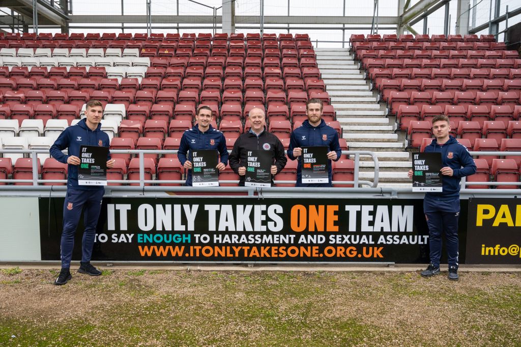 Harvey Lintott, Ben Fox, Stephen Mold, Lee Burge and Sam Hoskins satanding by the It Only  Takes One advertising board at Sixfields Stadium 